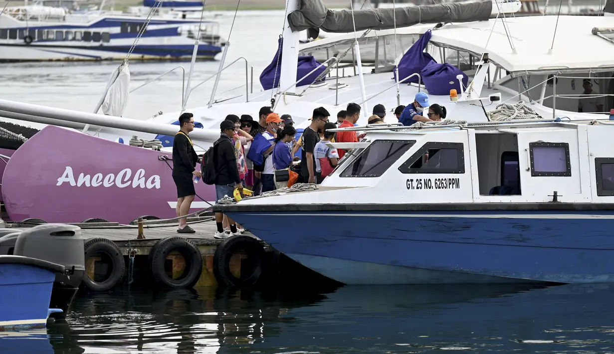 Turis Tiongkok menaiki kapal cepat untuk perjalanan dari Pulau Serangan ke Pulau Lombok di Denpasar, Bali, Rabu (25/1/2023). Aktivitas pariwisata khususnya dari China di Kelurahan Serangan, Denpasar Selatan semakin ramai. (AFP/Sonny Tumbelaka)