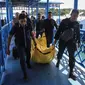 Anggota kepolisian mengangkat kantong jenazah yang berisikan puing-puing dan barang-barang dari jatuhnya pesawat jenis M-28 Skytrcuk milik Polri di Pelabuhan Telaga Punggur, Batam, Kepulauan Riau, Minggu (4/12). (Antara Foto/M N Kanwa/via REUTERS)