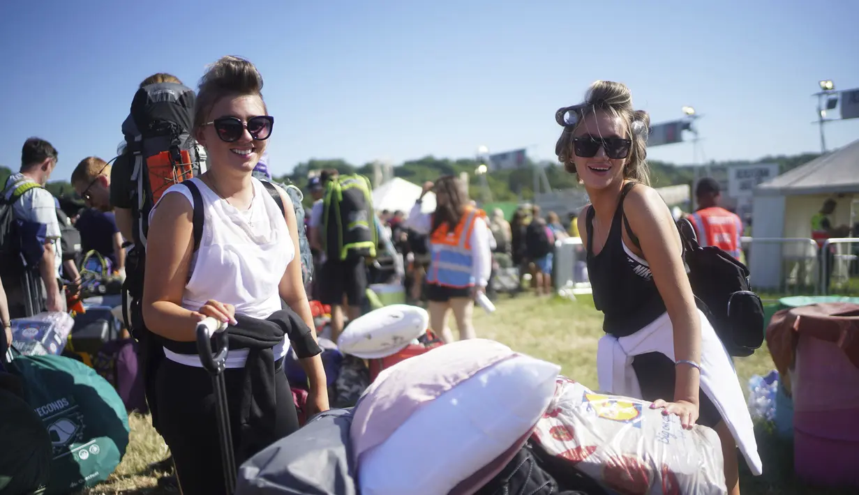 Dua wanita mengenakan kaca mata saat tiba di hari pertama Festival Glastonbury di Worthy Farm di Somerset, Inggris, Rabu (22/6/2022). Lebih dari 200.000 penggemar musik dan megabintang Paul McCartney, Billie Eilish, dan Kendrick Lamar turun ke pedesaan Inggris minggu ini saat Festival Glastonbury kembali setelah festival jeda tiga tahun. (Yui Mok/PA via AP)