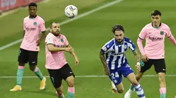 Bek Barcelona, Jordi Alba, berebut bola dengan pemain Alaves, Jose Peleteiro, pada laga Liga Spanyol di Stadion Mendizorroza, Minggu (1/11/2020). Kedua tim bermain imbang 1-1. (AP Photo/Alvaro Barrientos)