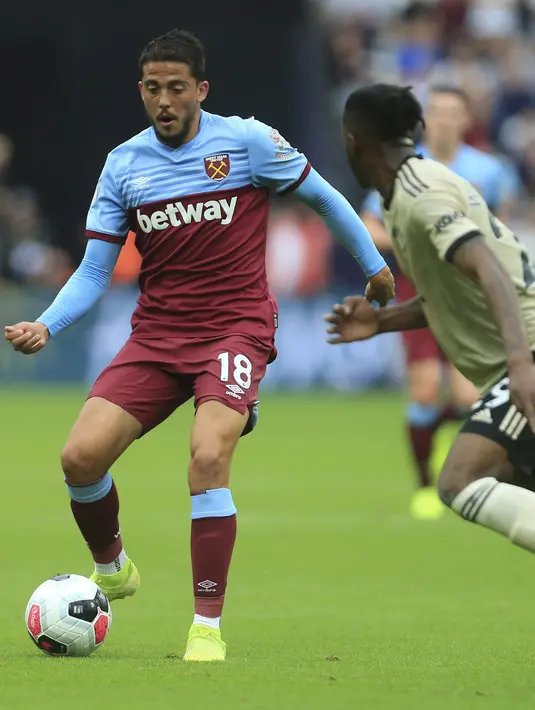 Gelandang West Ham, Pablo Fornals mengumpan bola dari kawalan bek Manchester United pada pertandingan lanjutan Liga Inggris di stadion London (22/9/2019). West Ham menang 2-0 atas Manchester United. (AP Photo/Leila Coker)