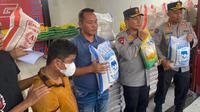 Tersangka dan Polda Riau memperlihatkan barang bukti beras oplosan di Pekanbaru.