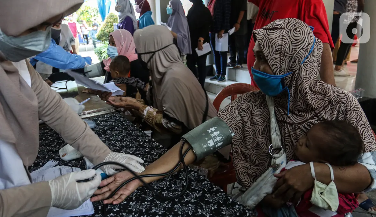 Warga saat dicek kesehatan sebelum menerima vaksin Pfizer dosis pertama di Kecamatan Beji, Depok,Rabu (1/9/2021). Pemerintah Kota Depok menggelar program Gebyar Vaksinasi Covid-19 secara serentak di 11 kecamatan di Kota Depok. (Liputan6.com/Johan Tallo)