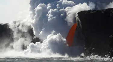 Aliran lava memancar deras dari gunung berapi Kilauea di Hawaii ke Samudra Pasifik, Rabu (1/2). Pertunjukkan alam tersebut menciptakan air terjun lava. (Shane Turpin / Lava Ocean Tours via AP)