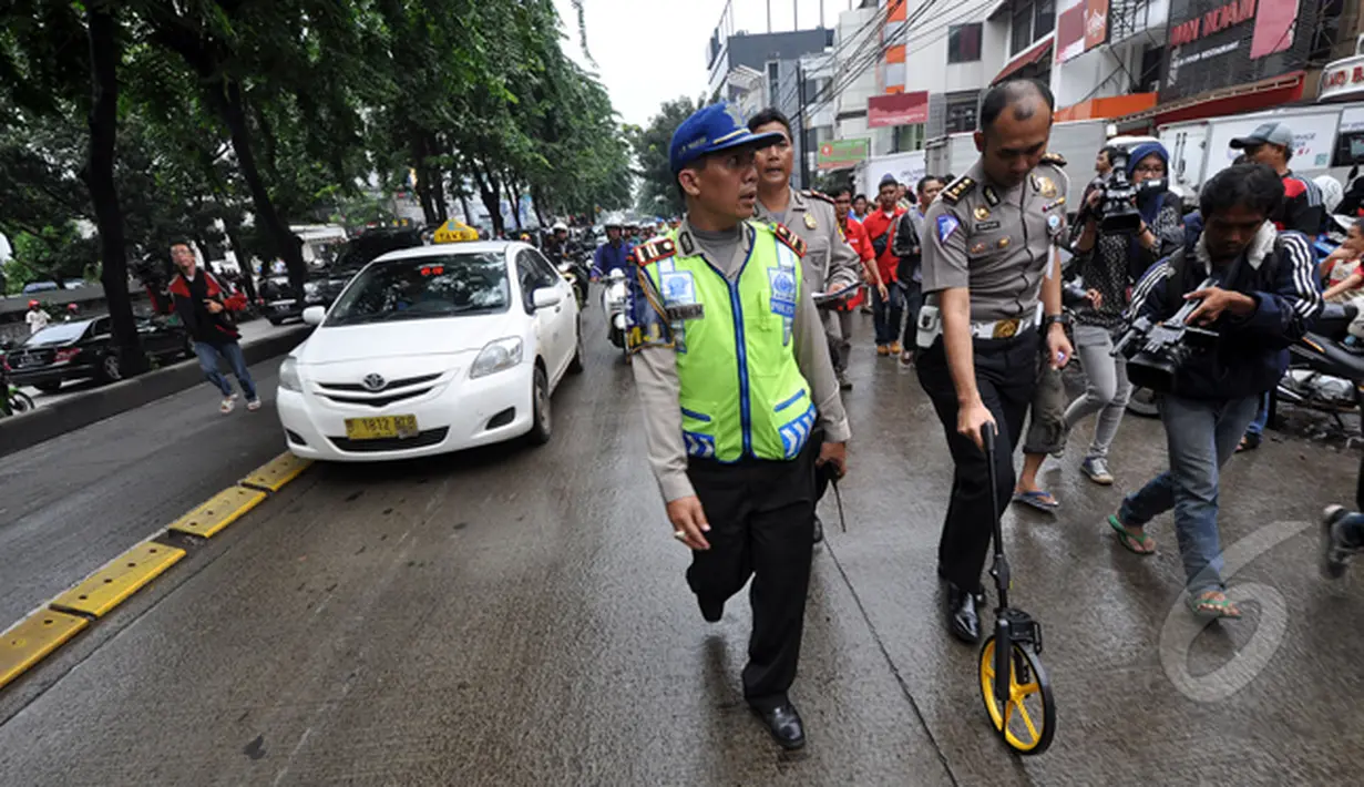 Petugas mengukur jarak terjadinya kecelakaan tabrakan Outlander saat olah TKP di Arteri Pondok Indah, Jakarta, Kamis (22/1/2015). (Liputan6.com/Miftahul Hayat)
