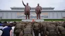 Tentara Rakyat Korea membungkuk di depan patung pemimpin Korea Utara, Kim Il Sung dan Kim Jong Il di Bukit Mansu, Pyongyang, pada peringatan 24 tahun kematian Kim Il Sung, Minggu (8/7). Kim Il-sung memimpin Korut sejak 1948 hingga 1994. (AFP/KIM Won-Jin)