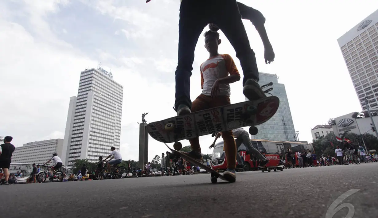 Beberapa remaja bermain skateboard saat hari bebas kendaraan (car free day) di kawasan Bundaran HI Jakarta, Minggu (14/12/2015). (Liputan6.com/Faizal Fanani)