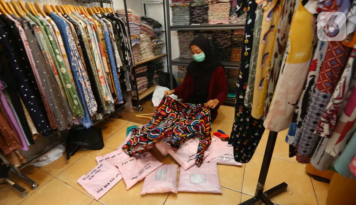 Pedagang mengemas baju pelanggan untuk pesanan online di salah satu outlet pakaian di Kawasan Tangerang, Banten, Rabu (9/2/2022). Badan Pusat Statistik (BPS) meyakini daya beli masyarakat makin membaik pada awal tahun 2022. (Liputan6.com/Angga Yuniar)