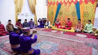 Rudy Salahuddin bersama istri saat menjalani prosesi adat Modepito yang berlangsung di Rujab Gubernur. Sumber : Diskominfotik (Arfandi Ibrahim/Liputan6.com)