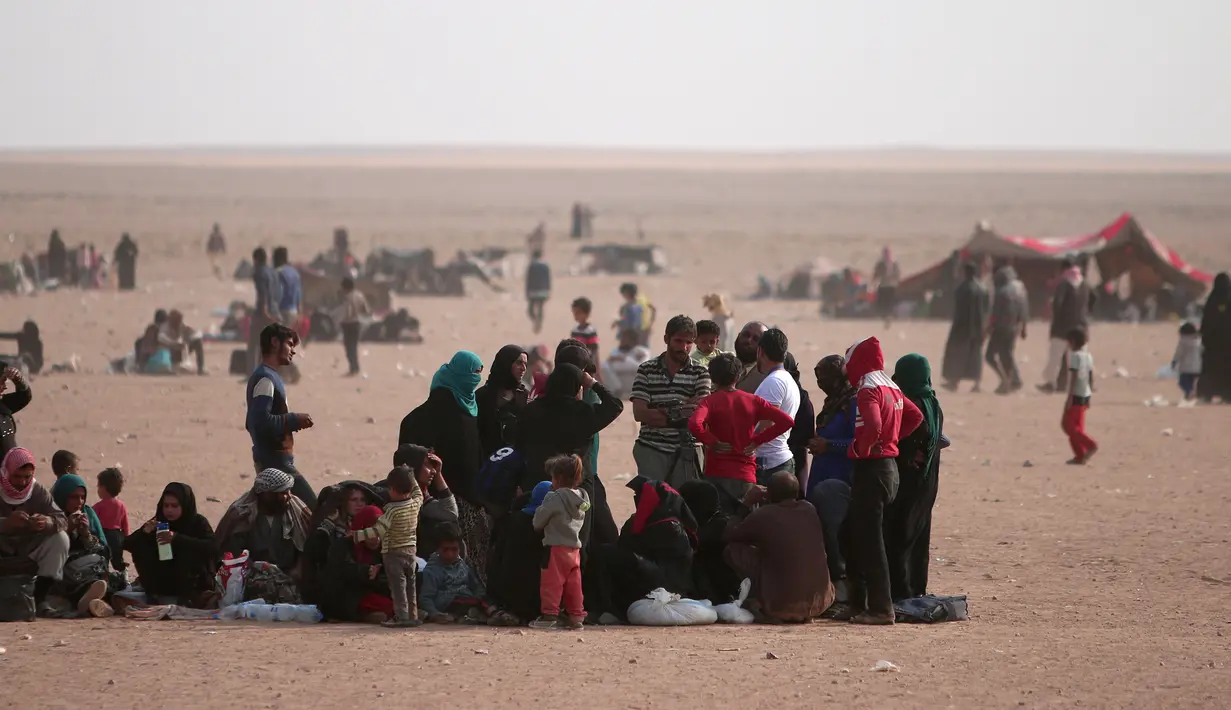 Pengungsi Irak beristirahat menunggu bantuan di dekat perbatasan Irak, di Hasaka Governorate (23/10). Para pengungsi Irak dan Suriah terlantar di tengah iklim gurun yang panas dan bahkan mendirikan tenda kecil untuk beristirahat. (REUTERS/Rodi Said)
