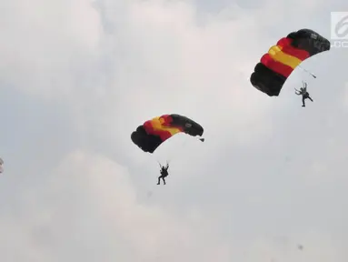 Aksi penerjun payung saat Festival Damai Millenial Road Safety di Monas, Jakarta, Minggu (23/6/2019). Aksi ini diikuti puluhan penerjun payung dari personel gabungan TNI-Polri. (merdeka.com/Iqbal Nugroho)