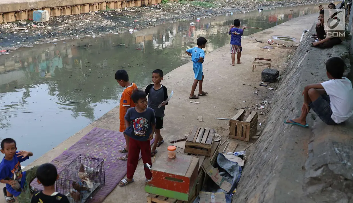 Anak-anak bermain di bantaran anak Sungai Ciliwung, Jakarta, Rabu (6/6). Meskipun tidak layak sebagai tempat bermain, namun lokasi itu menjadi tempat bagi anak-anak di kawasan tersebut untuk menunggu waktu berbuka. (Liputan6.com/Immanuel Antonius)
