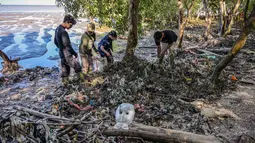 Dalam rangka peringatan Hari Mangrove Sedunia yang jatuh pada 26 Juli 2025, sejumlah relawan dari Ecological Observation and Wetlands Conservation (ECOTON) mengumpulkan sampah plastik dari rawa bakau di Surabaya, Jawa Timur. (Juni KRISWANTO/AFP)