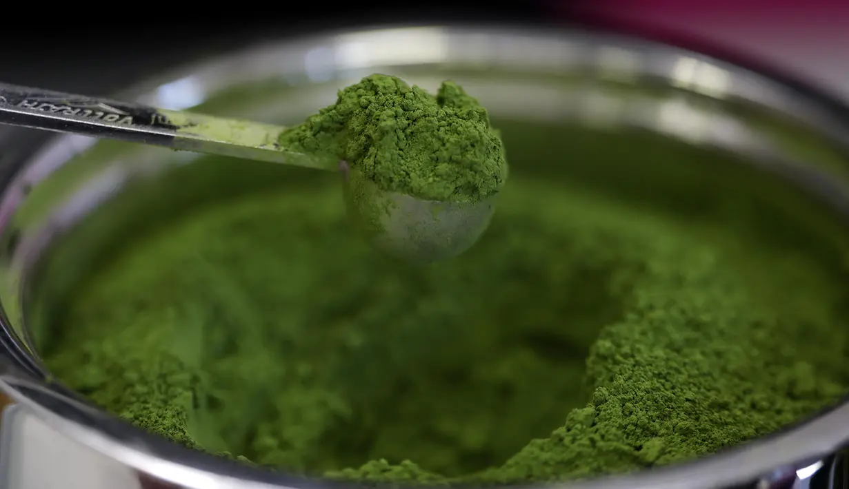 Sam Butarbutar mengambil sesendok matcha dari wadah sambil membuat minuman matcha di Third Culture, Berkeley, California, Amerika Serikat pada 15 Juli 2025. (Justin Sullivan/Getty Images North America/Getty Images via AFP)