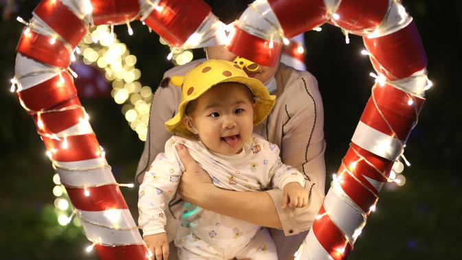Balita berpose untuk berfoto dengan dekorasi Natal di Yangon, Myanmar(10/12/2020). Berbagai dekorasi hingga akseoris dipasang untuk menyambut Natal di kota tersebut. (Xinhua/U Aung)