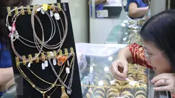 Calon pembeli melihat emas di pusat penjualan emas kawasan Cikini, Jakarta, Senin (12/10/2015). Harga emas yang dijual PT Antam Tbk hari ini turun Rp11.000 ke Rp556.000 per gram dari sebelumnya Rp567.000 per gram. (Liputan6.com/Angga Yuniar)