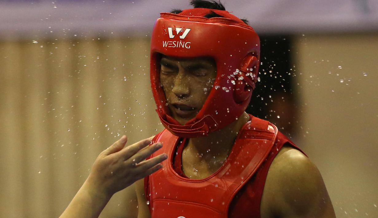 Atlet Wushu Asal China, menerima cipratan air dari pelatihnya pada nomor Sanda Kejuaraan Dunia Wushu 2015 di Istora, Senayan, Jakarta,Rabu (18/11/2015). (Bola.com/Nicklas Hanoatubun)