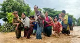 Warga berjalan melintasi banjir di Pyinmana di wilayah Naypyidaw, Myanmar, pada tanggal 13 September 2024. (Sai Aung MAIN/AFP)