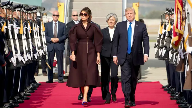 Melania Trump tiba di Seoul mengenakan gaun jas warna merah burgundy seperti buah plum dan dipadu dengan stiletto biru menyala. (Sumber AP/US Embassy in Korea)