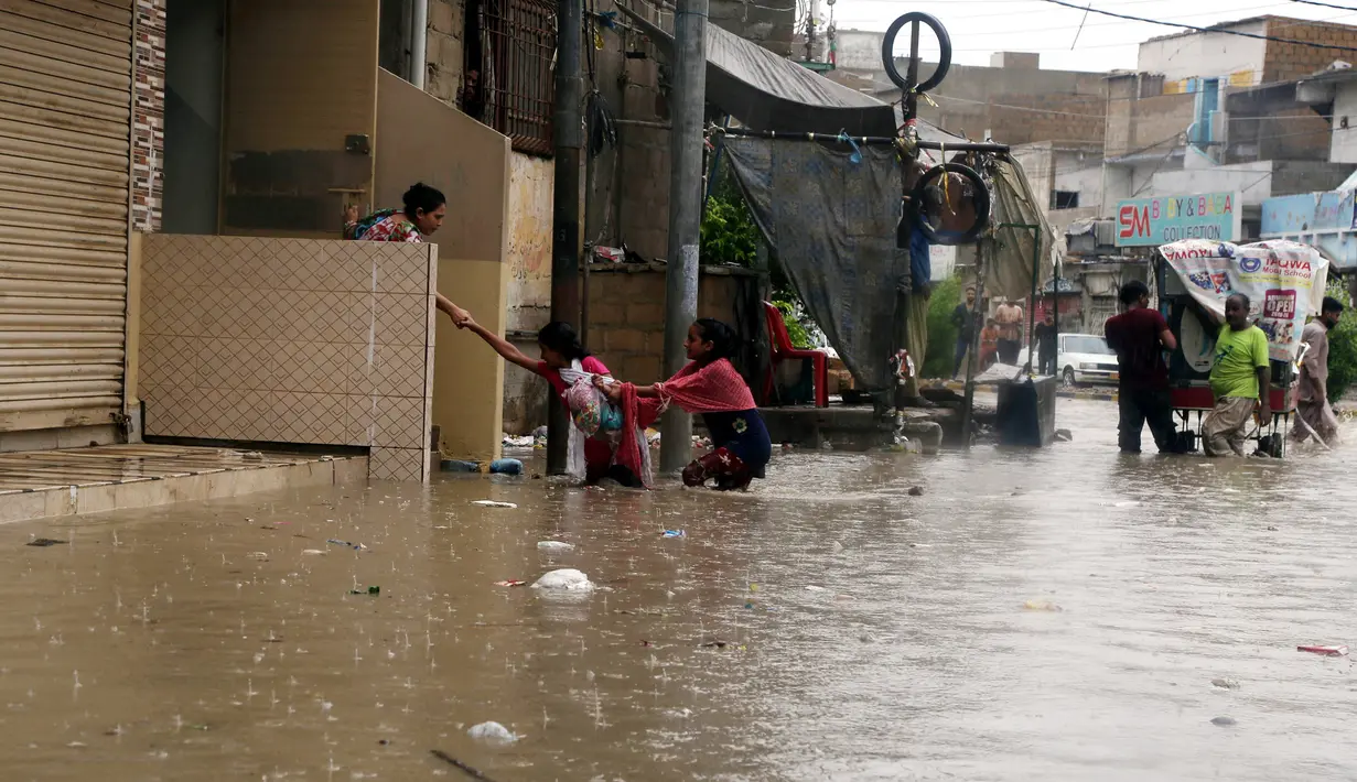Orang-orang berjalan menembus genangan air banjir setelah hujan monsun mengguyur deras di Kota Karachi, Pakistan, 25 Agustus 2020. Menurut Departemen Meteorologi Pakistan, hujan monsun yang lebat pada Agustus ini memecahkan rekor sebagai curah hujan tertinggi dalam 36 tahun terakhir. (Xinhua/Str)