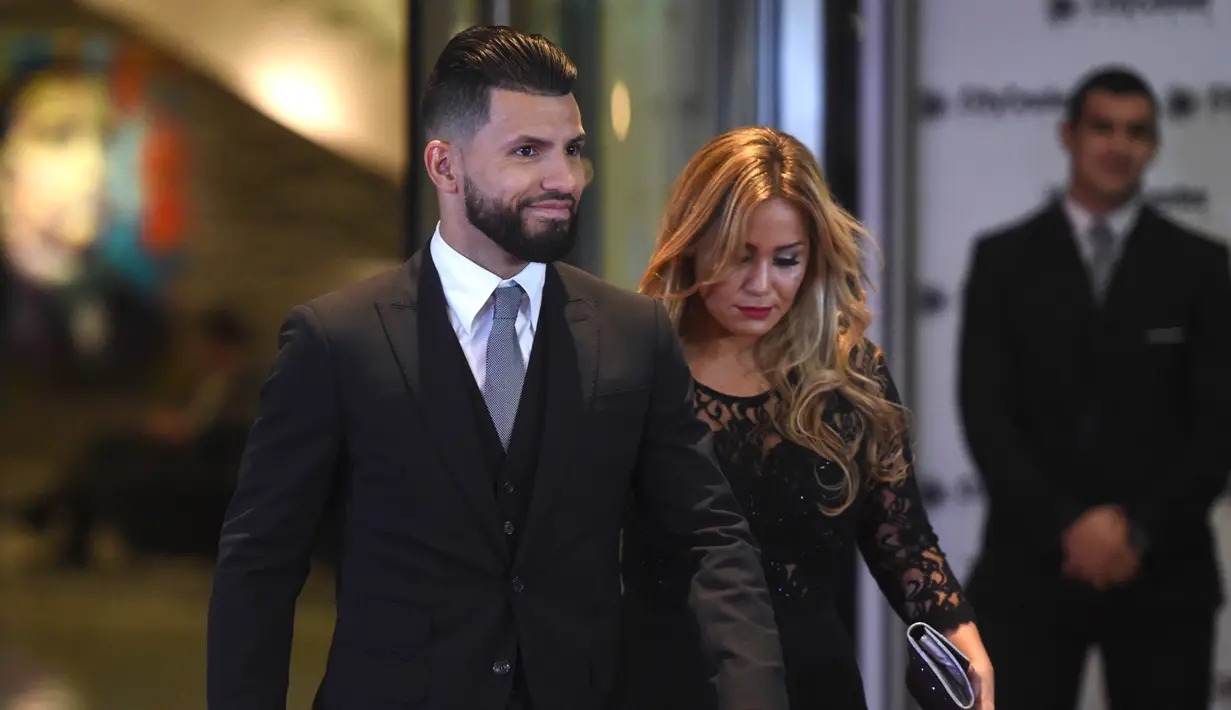 Pemain Manchester City, Argentina Sergio Aguero dan pacarnya berjalan di atas karpet merah saat menghadiri pernikahan Lionel Messi di Rosario, Argentina (30/6). (AFP Photo/Eitan Abramovich)