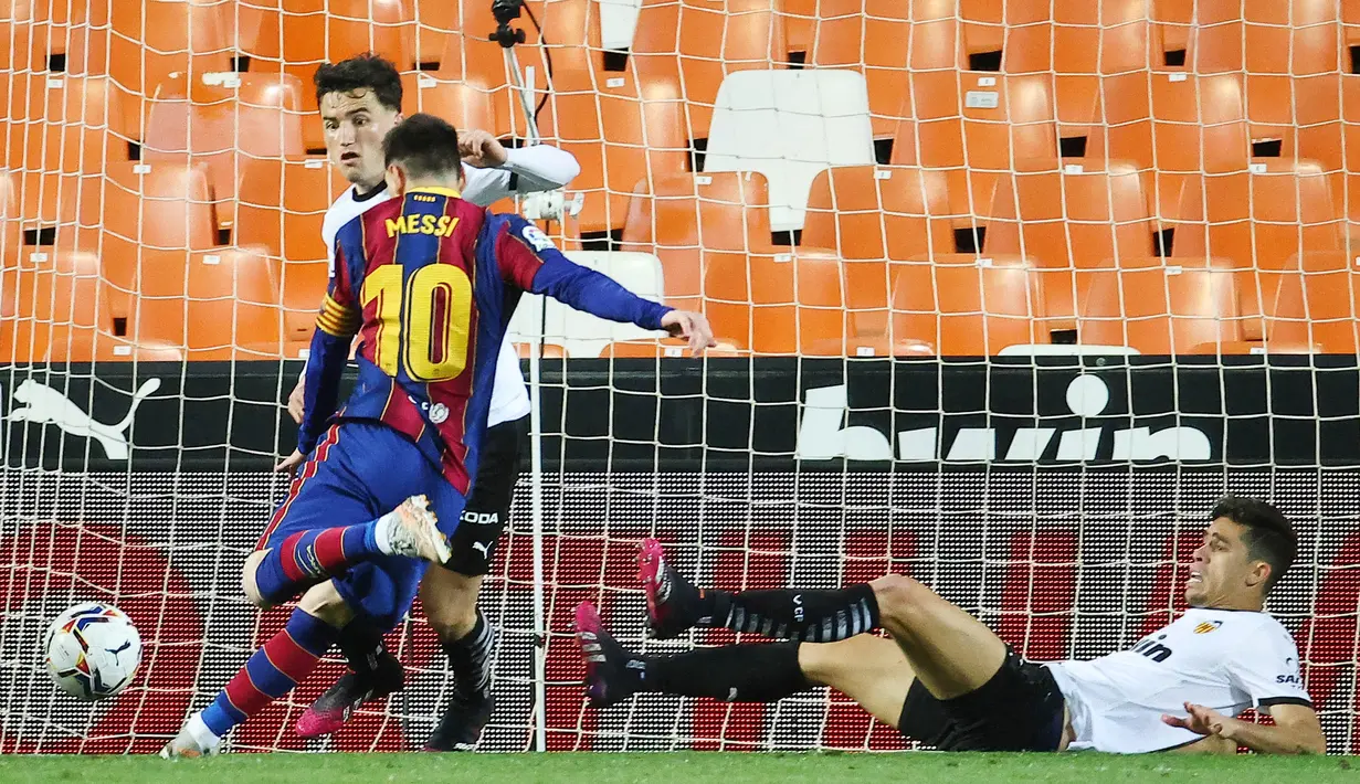 Striker Barcelona, Lionel Messi, mencetak gol ke gawang Valencia pada laga Liga Spanyol di Stadion Mestalla, Minggu (2/5/2021). Barcelona menang dengan skor 2-3. (AFP/Jose Jordan)