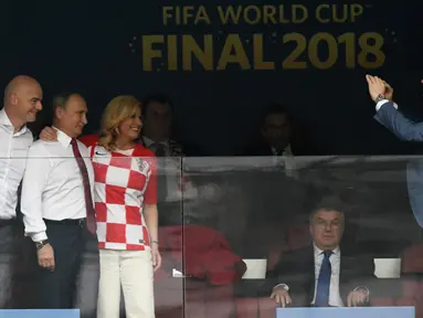 Presiden Prancis Emmanuel Macron, Presiden FIFA Gianni Infantino, Presiden Rusia Vladimir Putin dan Presiden Kroasia Kolinda Grabar-Kitarovic foto bersama menjelang final Piala Dunia 2018 di Stadion Luzhniki, Moskow (15/7). (AFP Photo/Christophe Simon)