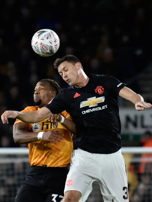 Gelandang Manchester United, Nemanja Matic melompat saat berebut bola dengan pemain Wolverhampton Wanderers, Adama Traore pada babak ketiga Piala FA di Molineux, Sabtu (4/1/2020). Wolverhampton dan MU dipaksa untuk melakukan laga ulangan di Old Trafford usai bermain imbang tanpa gol. (AP/Rui Vieira)