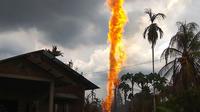 Orang-orang berusaha memadamkan sumur minyak ilegal milik warga yang terbakar di Peureulak, Provinsi Aceh, Rabu (25/4). Kebakaran sumur minyak tersebut menghaguskan tiga rumah penduduk dan dua lainnya rusak berat. (ILYAS ISMAIL/AFP)