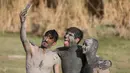 Tiga pasukan Irak berselfie dengan tubuh dipenuhi belerang di Hammam al-Ali, Mosul, Irak, 9/11). Di tengah perang melawan ISIS, mereka melepaskan penat dan lelah dengan berenang di Kolam belerang. (REUTERS/Alaa Al-Marjani)