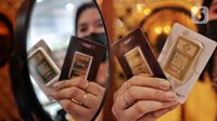 Pegawai menunjukan emas batangan di Galeri 24, Jakarta, Selasa (13/9/2022). Harga emas Antam dipatok dengan harga Rp 950.000 per gram. (Liputan6.com/Angga Yuniar)