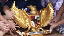 Anak-anak melihat lambang burung Garuda Pancasila di Kampung Pancasila, Karang Tengah, Kota Tangerang, Selasa (1/6/2021). Kegiatan tersebut antara lain seperti gotong royong membersihkan kampung dan sosialisasi penanaman nilai Pancasila kepada warga . (Liputan6.com/Angga Yuniar)