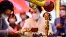 <p>Jemaah mencuci patung Buddha saat kebaktian untuk merayakan ulang tahun Buddha di Kuil Jogye, Seoul, Korea Selatan, Minggu (8/5/2022). (ANTHONY WALLACE/AFP)</p>