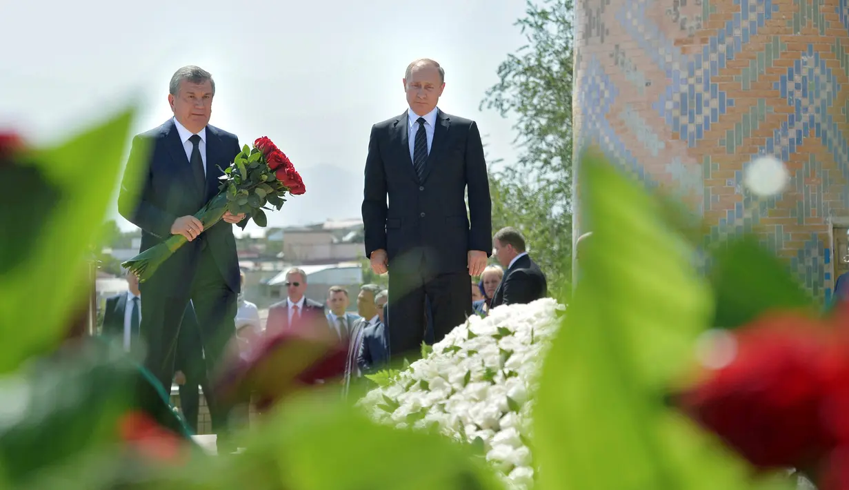 Presiden Rusia Vladimir Putin (kanan) dan PM Uzbekistan Shavkat Mirziyoyev saat akan meletakkan bunga mawar di makam mendiang Presiden Uzbekistan Islam Karimov di kota bersejarah Samarkand, Selasa (6/9). (Sputnik/Kremlin/Alexei Druzhinin/ REUTERS)