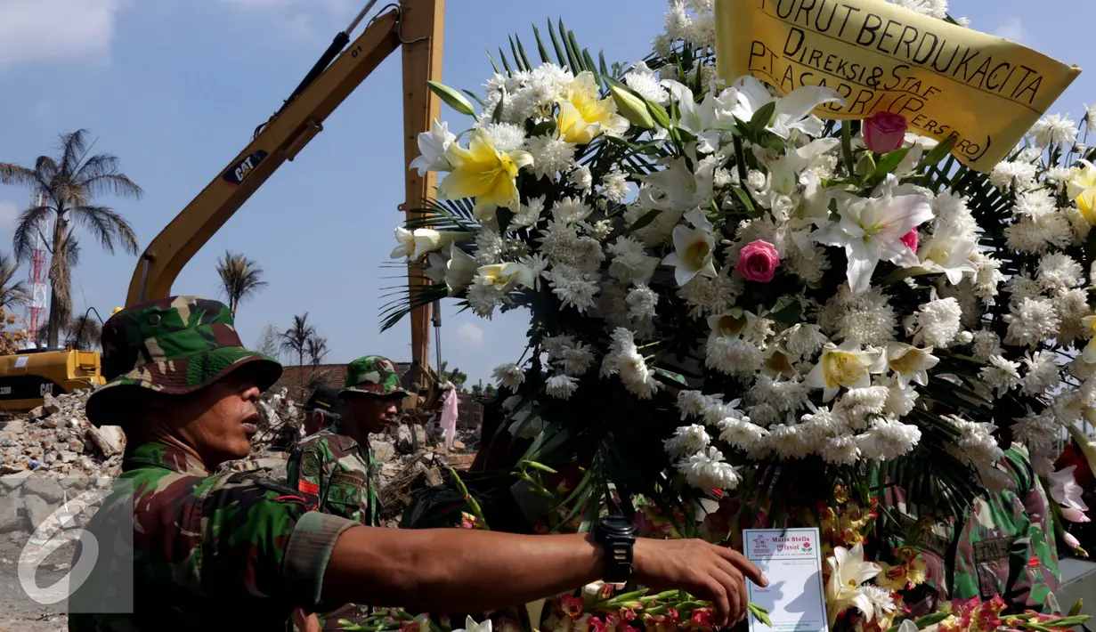 Anggota TNI mengatur Karangan bunga yang datang di lokasi jatuhnya pesawat hercules C 130 di jalan jamin ginting, Medan, Kamis (2/7/2015). Karangan bunga sebagai simbol duka cita atas peristiwa yang merenggut ratusan nyawa. (Liputan6.com/Johan Tallo)