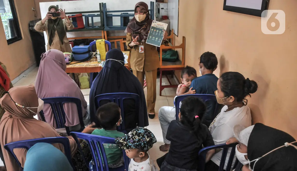 Petugas Promosi Kesehatan Puskesmas Kecamatan Menteng saat sosialisasi pencegahan Hepatitis Akut di Rukun Warga 03, Kelurahan Cikini, Jakarta, Senin (23/5/2022). Sosialisasi guna mencegah penyebaran sekaligus mengimbau warga menerapkan Pola Hidup Bersih dan Sehat (PHBS) agar terhindar penyakit Hepatitis Akut yang marak menyerang anak-anak. (merdeka.com/Iqbal S Nugroho)