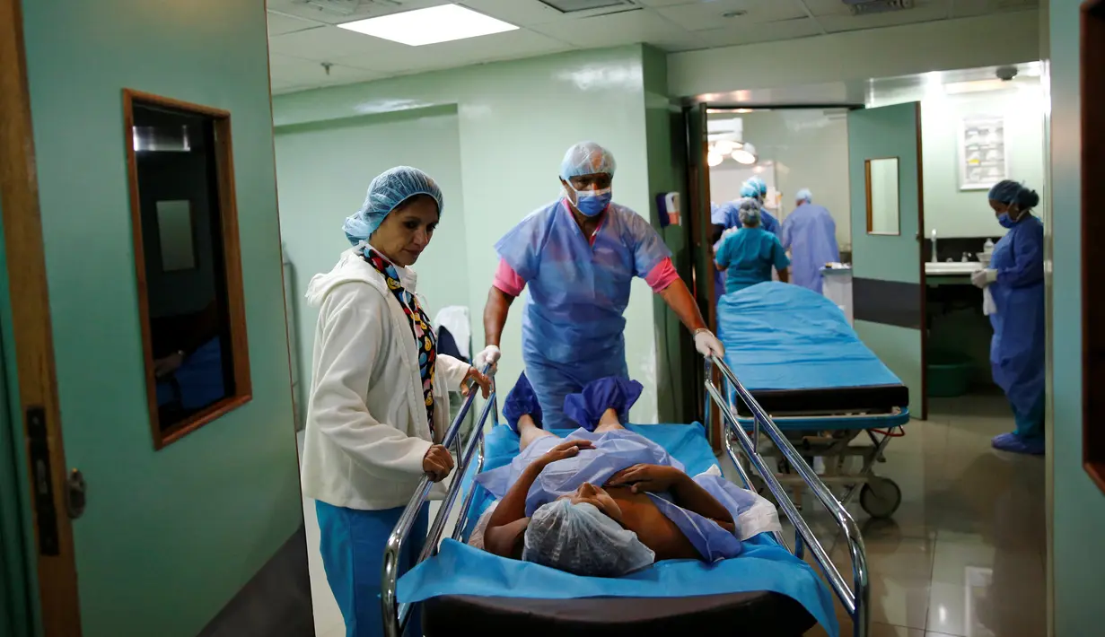 Tenaga medis memindahkan pasien usai operasi sterilisasi di sebuah rumah sakit di Caracas, 27 Juli 2016. Krisis ekonomi parah yang melanda Venezuela membuat banyak wanita memilih operasi sterilisasi untuk mencegah kehamilan (REUTERS/Carlos Garcia Rawlins)