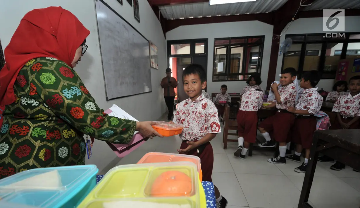 Siswa menerima makanan tambahan saat program Penyediaan Makanan Tambahan Anak Sekolah (PMTAS) di SD Negeri 01 Tanjung Priok, Jakarta, Kamis (28/3). Pemprov DKI Jakarta menggelontorkan dana Rp 324 miliar untuk memenuhi gizi anak SDN di Jakarta dengan program PMTAS. (merdeka.com/Iqbal S. Nugroho)
