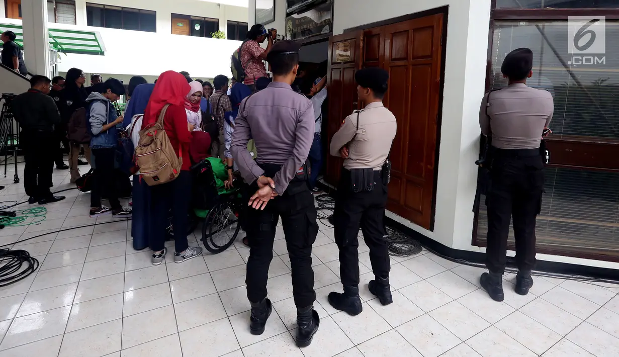 Petugas kepolisian berjaga di luar ruang sidang perdana praperadilan yang diajukan Ketua DPR Setya Novanto di PN Jakarta Selatan, Kamis (30/11). Novanto mengajukan praperadilan atas penetapannya sebagai tersangka korupsi E-KTP. (Liputan6.com/Johan Tallo)