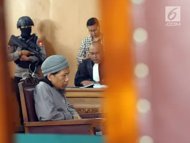 Terdakwa sejumlah kasus tindak pidana terorisme, Aman Abdurrahman saat mengikuti pembacaan tuntutan JPU di PN Jakarta Selatan, Jumat (18/5). Sidang dijaga ketat puluhan personel gabungan bersenjata lengkap. (Liputan6.com/Helmi Fithriansyah)
