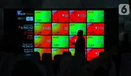 Karyawan melintasi layar yang menampilkan Indeks Harga Saham Gabungan (IHSG) saat acara Penutupan Perdagangan Bursa Efek Indonesia Tahun 2022 di Jakarta, Jumat (30/12/2022). PT Bursa Efek Indonesia (BEI) mencatat ada 59 perusahaan yang melakukan Initial Public Offering (IPO) atau pencatatan saham sepanjang 2022. Pada penutupan perdagangan akhir tahun, Indeks Harga Saham Gabungan (IHSG) ditutup lesu 0,14% atau 9,46 poin menjadi 6.850,62. (Liputan6.com/Angga Yuniar)