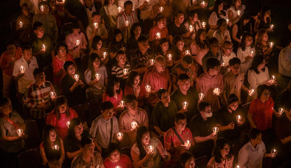Umat Kristiani menyalakan lilin selama misa Hari Natal di Gereja Bethany, Surabaya, Jawa Timur pada Kamis 25 Desember 2025. Puluhan ribu umat Kristiani memadati Gereja Bethany Nginden Surabaya untuk mengikuti ibadah Natal pada Kamis (25/12/2025) malam. (JUNI KRISWANTO/AFP)