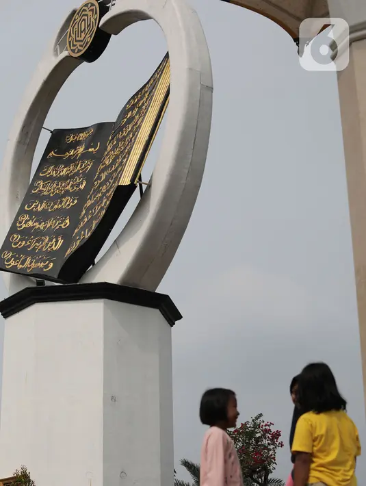 Anak-anak berada di dekat tugu Al-Quran di Masjid Istana Anak Yatim, Desa Cikeas Udik, Gunung Putri, Kabupaten Bogor, Jawa Barat, Jumat (30/4/2021). Tugu Al Quran ini memiliki tinggi 18 meter dan lebar delapan meter. (Liputan6.com/Herman Zakharia)