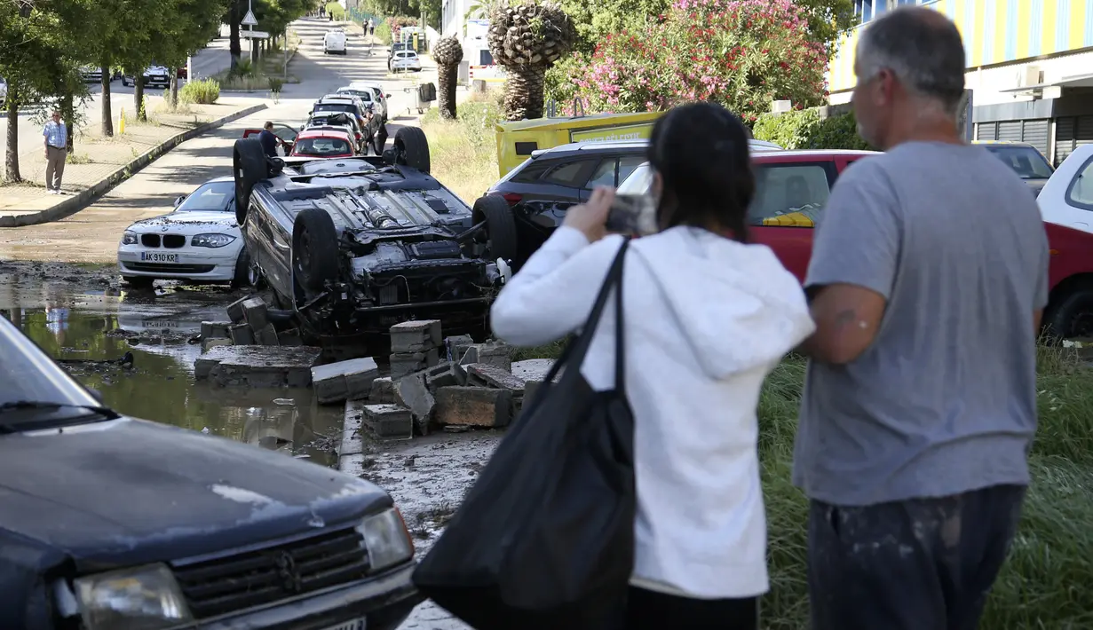 Warga melihat pemandangan kerusakan akibat banjir bandang melanda Kota Ajaccio, Prancis (11/6/2020). Bencana tersebut mengakibatkan sekitar 200 orang terpaksa mengungsi ke tempat aman setelah banjir bandang memporak-porandakan Kota Ajaccio. (AFP/Pascal POCHARD-CASABIANCA)
