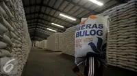 Pekerja memanggul karung Beras milik Badan Urusan Logistik (Bulog) di Gudang Bulog kawasan Kelapa Gading, Jakarta Utara, Selasa (7/6). Bulog memiliki stok beras sebanyak 2,1 juta ton. (Liputan6.com/Johan Tallo)