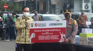 Chief Network Officer Siloam Hospitals Group Hendy Widjaja secara simbolis menyerahkan donasi kepada Kapolda Metro Jaya Irjen Fadil Imran di Polda Metro Jaya, Jakarta, Jumat (30/7/2021). Donasi berupa 15000 Surgical Gown, 15000 Masker Media dan 15000 Sarung Tangan. (Liputan6.com/Pool)