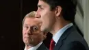 PM Irlandia Enda Kenny memperhatikan PM Kanada Justin Trudeau saat konferensi pers usai melakukan pertemuan di Montreal, Kamis (4/5). Dalam pertemuan itu Trudeau membuat heboh lantaran kaus kaki yang dikenakannya. (Paul Chiasson/The Canadian Press via AP)