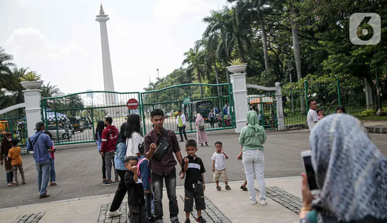 <p>Warga berfoto di halaman luar Monumen Nasional (Monas) Jakarta, Kamis (5/5/2022). Meski kawasan Monas masih ditutup sejak awal pandemi COVID-19 pada Maret 2020 lalu namun tidak menyurutkan minat warga untuk bisa berwisata yaitu dengan memanfaatkan kawasan luar monumen tersebut. (Liputan6.com/Faizal Fanani)</p>