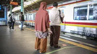 Penumpang berdiri di garis antrean penumpang di Stasiun Juanda, Jakarta, Kamis (10/8). PT KAI Commuter Jabodetabek melakukan uji coba garis antrean penumpang tersebut guna untuk keselamatan bagi para penumpang. (Liputan6.com/Faizal Fanani)