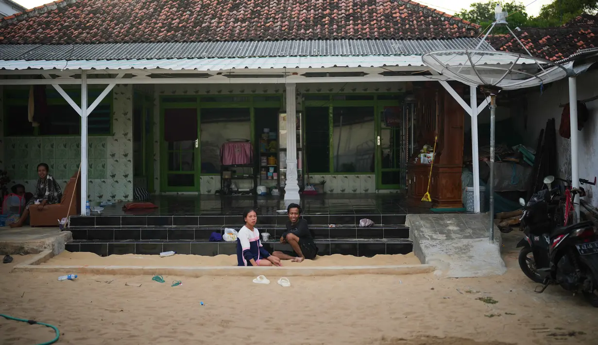 Warga menghabiskan sore mereka di bak pasir yang tersedia di hampir setiap rumah di Desa Legung Timur, Sumenep, Madura, Selasa 9 September 2025. (AP Photo/Dita Alangkara)